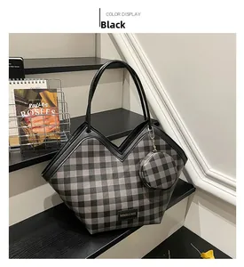 Détail du sac cabas à carreaux avec porte-monnaie assorti et étiquette sur escalier