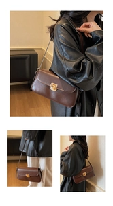 Dettaglio di una borsa a tracolla vintage in pelle marrone con chiusura in metallo dorato