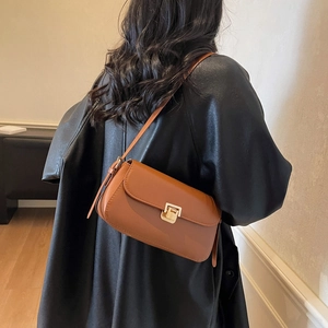 Classic brown leather underarm shoulder bag with a gold rectangular metal swivel lock