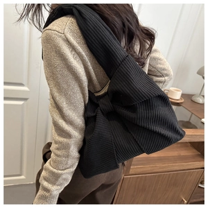 Detailed texture of black corduroy tote bag featuring a large decorative vintage bow design