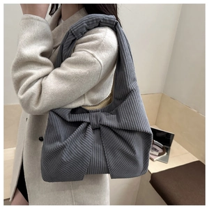 Detail of the oversized bow design on this blue-grey corduroy shoulder tote bag