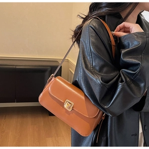 Detail of a brown vintage leather shoulder bag with a square gold metallic twist-lock