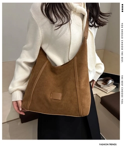 Brown suede hobo shoulder bag styled with warm interior aesthetic for winter fashion