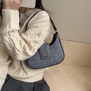 Blue textured crescent shoulder bag with brown leather strap and silver M logo