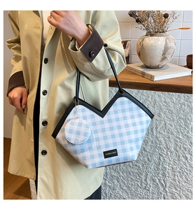 Detail of blue plaid tote bag with V-shaped cut and matching round coin purse charm