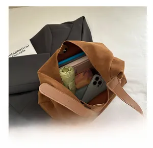 Spacious brown faux suede tote bag showing large capacity for umbrella, phone and notebook