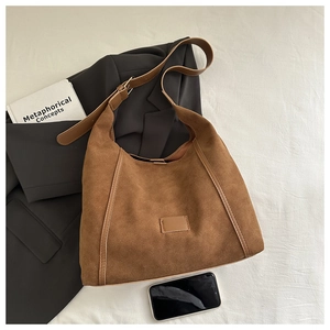 Détail du sac cabas en cuir givré marron foncé avec bordure lisse sur tissu blanc