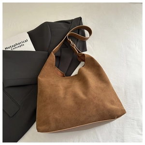 Détail du sac hobo en daim marron avec bandoulière réglable et fini mat texturé