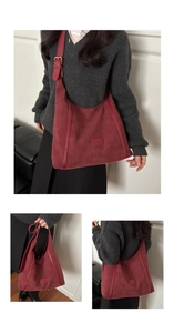 Détail macro du sac hobo en daim bordeaux avec bandoulière large et boucle dorée