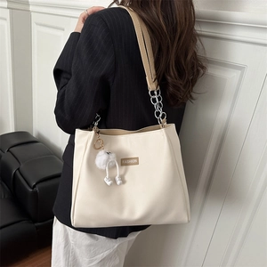 Minimalist beige tote bag with chain strap and plush pendant in a 2025 trendy style