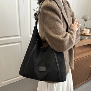 Grand sac cabas noir vintage porté par un mannequin dans un décor rétro chaleureux