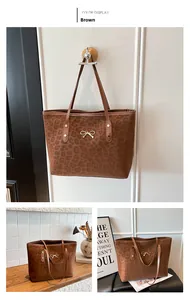 Detail view of large brown leopard print tote bag with gold bow clasp and shoulder straps