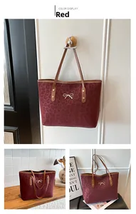 Detailed view of red leopard print tote bag featuring a golden bow accent and thin handles