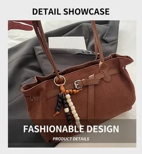 Détail du sac en daim mat marron avec sangle en cuir et pendentif en perles décoratives