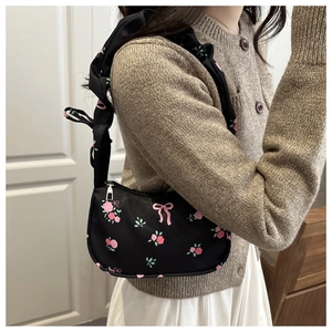 Sac hobo floral avec motif de roses et bandoulière à volants porté par un modèle