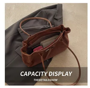 Vue intérieure du cabas en daim marron montrant sa grande capacité pour accessoires