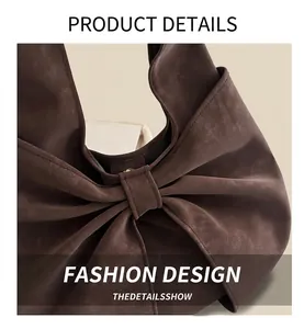 Detailed close-up of brown suede tote bag with large bow design and premium metal buckle