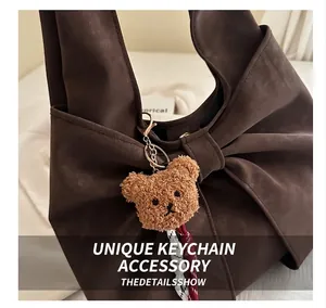 Detail of dark brown bow-shaped shoulder bag with a cute plush bear charm accessory