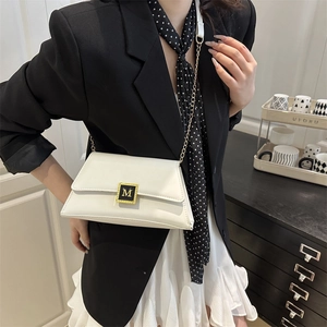 Minimalist white leather flap shoulder bag with gold M buckle and chain strap