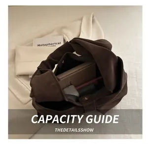 Interior storage space of dark brown suede handbag with knotted handle design