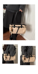 Détail d'un grand sac fourre-tout beige en suède avec pendentif ethnique en bois