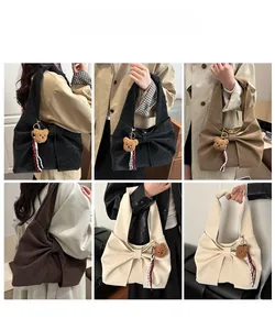 Detail view of large suede tote bags with bow decoration in black, khaki, and brown tones