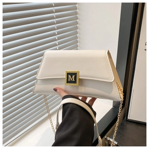 Detail of white PU leather crossbody bag with gold M buckle and elegant chain strap