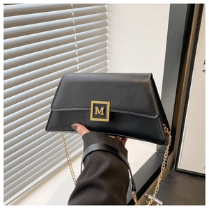 Black matte leather pillow bag with gold M buckle and chain strap for shoulder and hand carry