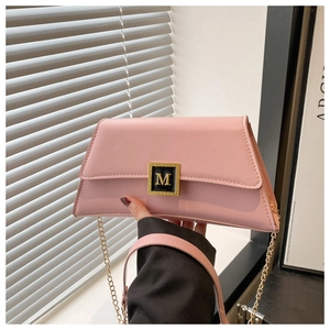 Detailed macro view of the pale pink leather bag with elegant gold M logo metal clasp
