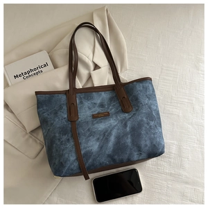 Detailed top view of large blue cloud-pattern tote bag with brown leather handles and props