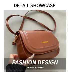 Detailed view of a brown leather saddle bag with gold FASHION text and stitching