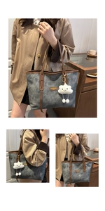 Detailed view of grey canvas tote with brown leather trim and white fluffy cloud charm