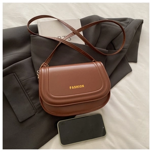 Detailed view of a vintage brown leather saddle bag with fashion engraving and shoulder strap