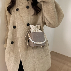 Mini borsa a secchiello malva con manico di perle e tracolla a catena dorata