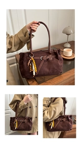 Detail of dark brown faux suede tote bag with wooden bead tassel and metal buckle