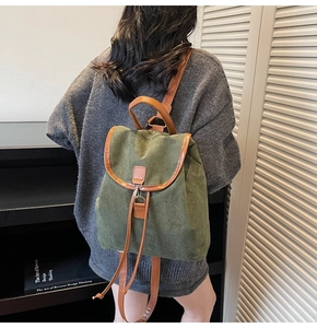 Détail d'un sac à dos rétro vert foncé avec boucle en cuir brun et rabat fermé