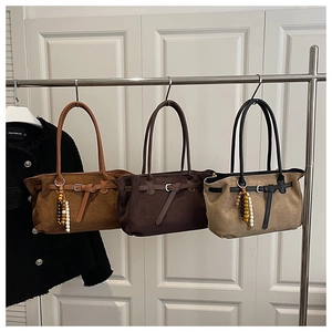 Detail of vintage suede tote bags in brown and khaki with decorative wooden beads