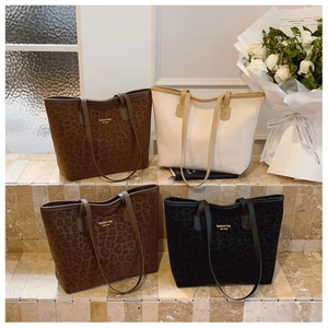 Four large capacity tote bags in leopard print and solid colors on stone steps
