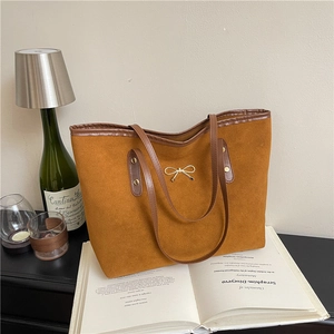 Chic mustard yellow matte tote bag with golden bow hardware and dark brown handles