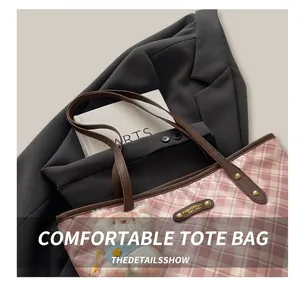 Détail du sac cabas à carreaux roses avec anses en cuir marron et pendentif peluche
