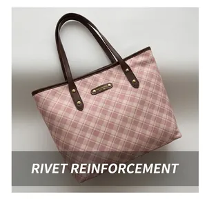 Détail du sac cabas à carreaux roses avec anses marron foncé et rivets dorés