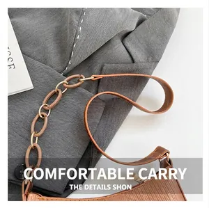 Detail of caramel brown textured leather handbag with unique acrylic chain strap