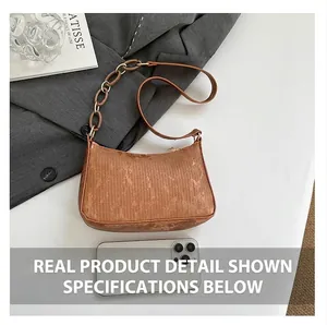 Close-up of brown corduroy shoulder bag with amber chain and leather strap details