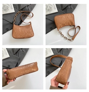 Detail view of brown corduroy underarm bag with leather and metal chain straps