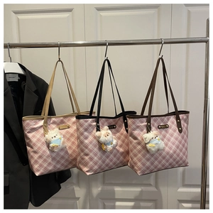 Detailed view of pink plaid tote bags with leather handles and cute bear pendants