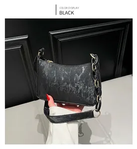Detail of black corduroy shoulder bag with gold chain strap and vertical texture finish