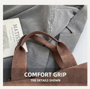 Detail of comfortable wide handle on brown velvet handbag with fine stitching accents
