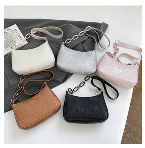Flat lay of velvet corduroy shoulder bags in five colors with decorative chains