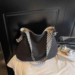 Large black corduroy tote bag with black and white striped straps and side knot details