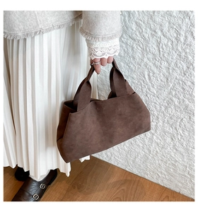 Deep brown suede tote bag details shown with elegant white pleated dress and lace cuff